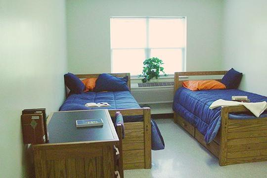 Dorm room with two beds and a desk at Keystone College